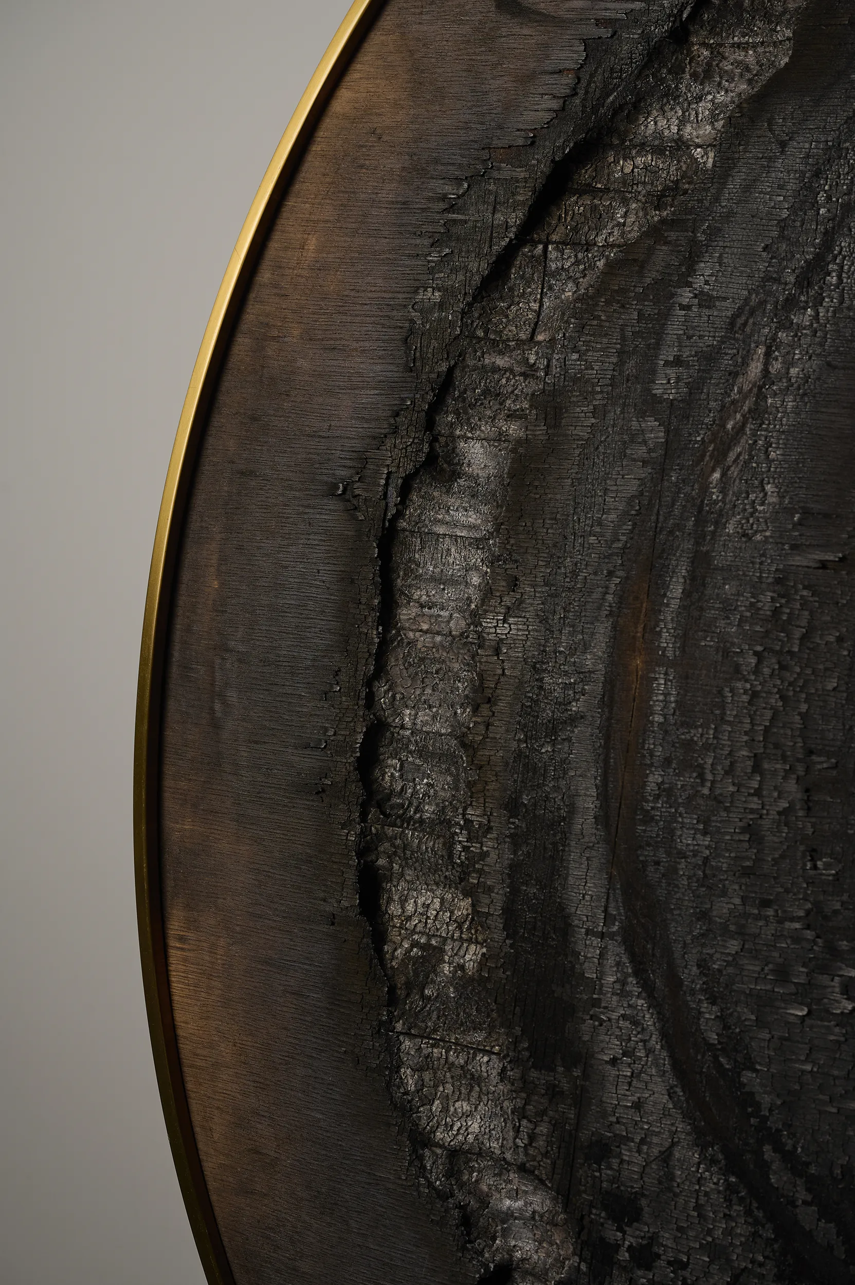 A close up view of the painting 'Helioocentrism'' from 2021 by artist Damian Boylan. The painting from the Fire Paintings series shows details of carbonised wood and surface strata